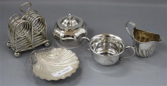 A George V silver scallop butter dish with glass liner, a serpentine oval tea caddy, a small cream jug, a sugar